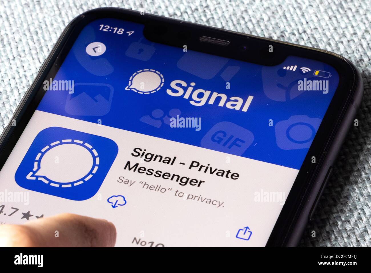 iPhone 11 on blue background with new messenger app Signal logo and icon displayed. Signal is a new application for messaging with high privacy Stock Photo