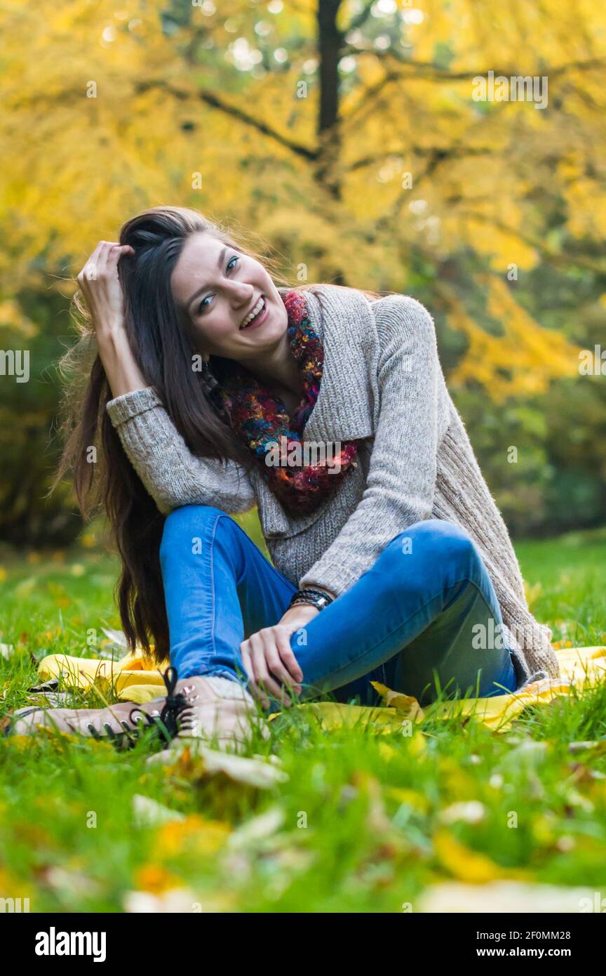 Happy girl sitting on grass Stock Photo - Alamy