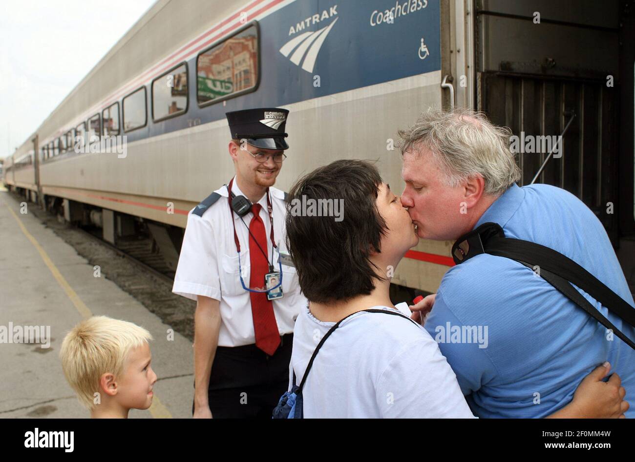 Amtrak assistant conductor Brandon Bostian stands by on Aug. 21, 2007 as  Sandra Palmer of University City says goodbye to her boyfriend, Clyde  Simpson, as he leaves for work in Chicago at
