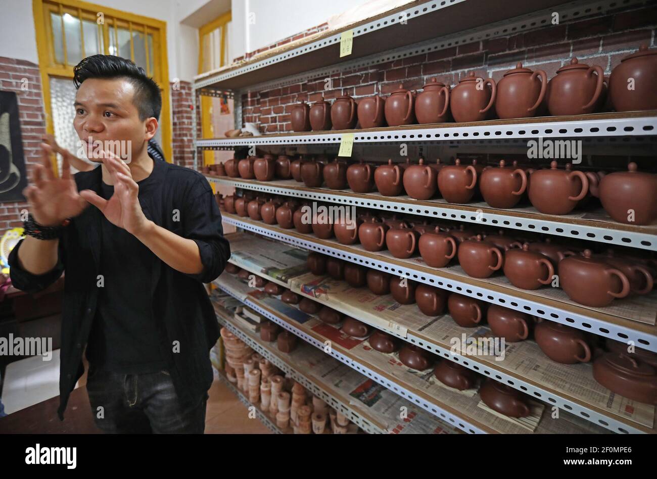 Chinese man Tang Tianyuan introduces Nixing pottery at his workshop in Wuzhou city, south China's Guangxi Zhuang autonomous region, 20 May 2019. If turning a habit into a career is a very fortunate thing, then you can call Tang Tianyuan from Guangxi Zhuang autonomous region a lucky dog, as he succeeded in not only building a business based on a passion but also working side by side with his schoolmates. Tang, born in the 1990s, has been playing with mud since he was a child, and later majored in ceramics and decorative sculpture design at college. While busy shuttling between classes, the stud Stock Photo