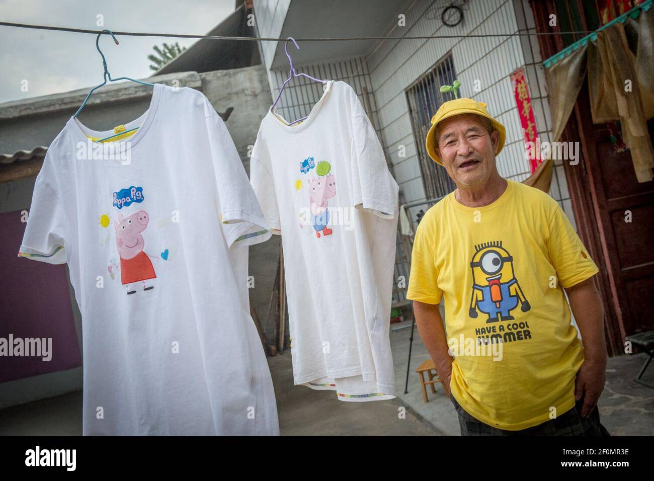In this undated photo, Chinese elderly man Chao Yougeng diagnosed with depression wearing a hat, which sells well on Alibaba's e-commerce platform Taobao, poses for photos at home in Zhumadian city, central China's Henan province. An elderly man diagnosed with depression about 10 years ago has been winning hearts online over the past two years thanks to short videos filmed by his granddaughter. The man Chao Yougeng from Zhumadian city in central China's Henan province received treatment in hospital for depression and relied afterwards on antidepressant drugs. His granddaughter posted first vid Stock Photo