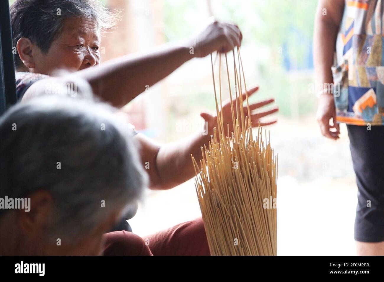 In this undated photo, Chinese workers sort out wheat straws on the Alibaba's e-commerce platform Taobao in Qingfeng county, Anyang city, central China's Henan province. Meng Fanyao of Henan sees the value in biodegradable wheat straws, which once lay idle in the past. With China's increasing awareness of environmentalism however, the straws are now being put to use. Having worked for some time away from his hometown, Meng returned to the countryside to start a business. He found that the local wheat straws are tall, brightly colored and of wide diameter, so Meng decided to seize the business  Stock Photo