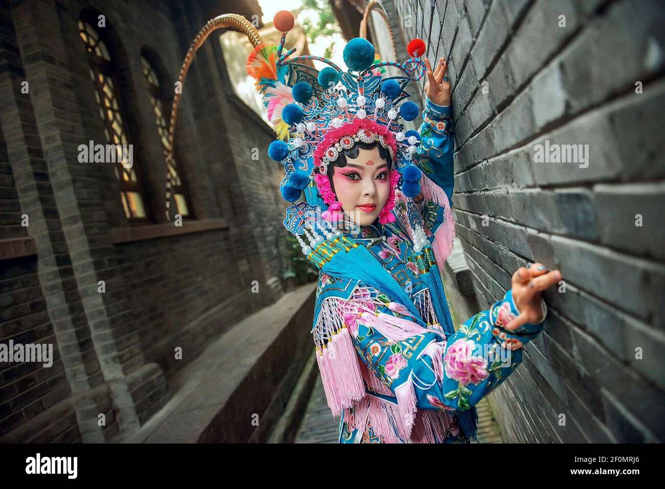 A tourist wearing Sichuan Opera costume poses for photos in Chengdu city, southwest China's Sichuan province. Chinese photographer You Hang captured a series of photos related with Sichuan Opera costumes in Chengdu city, southwest China's Sichuan province, which went viral on the internet. (Photo by Yi fang - Imaginechina/Sipa USA) Stock Photo