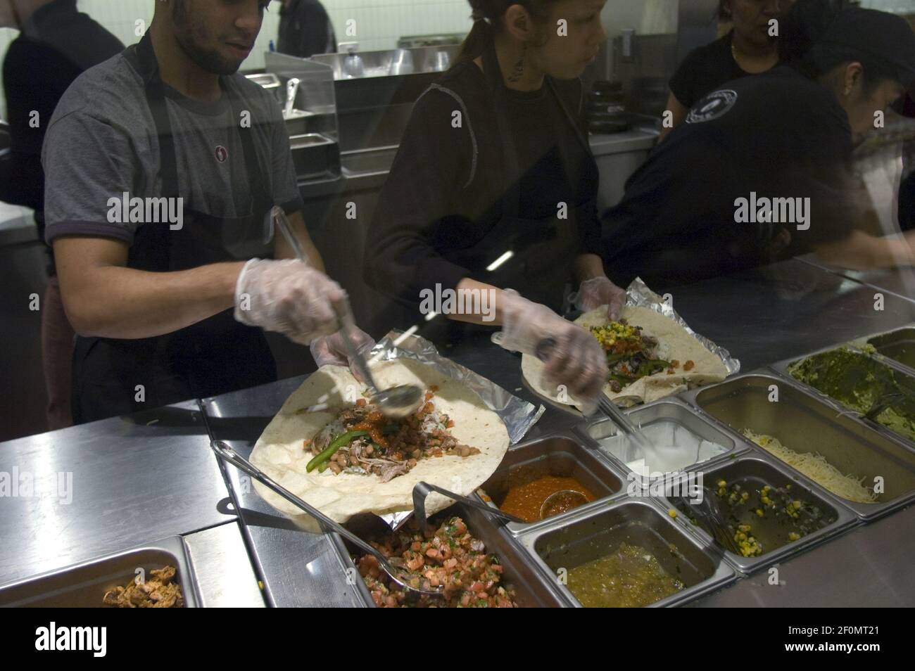 Workers prepare burritos at a Chipotle Mexican Grill in Midtown in New York  on Tuesday, December 16, 2008. New York City is suing Chipotle over alleged  labor law violations, specifically the predictable