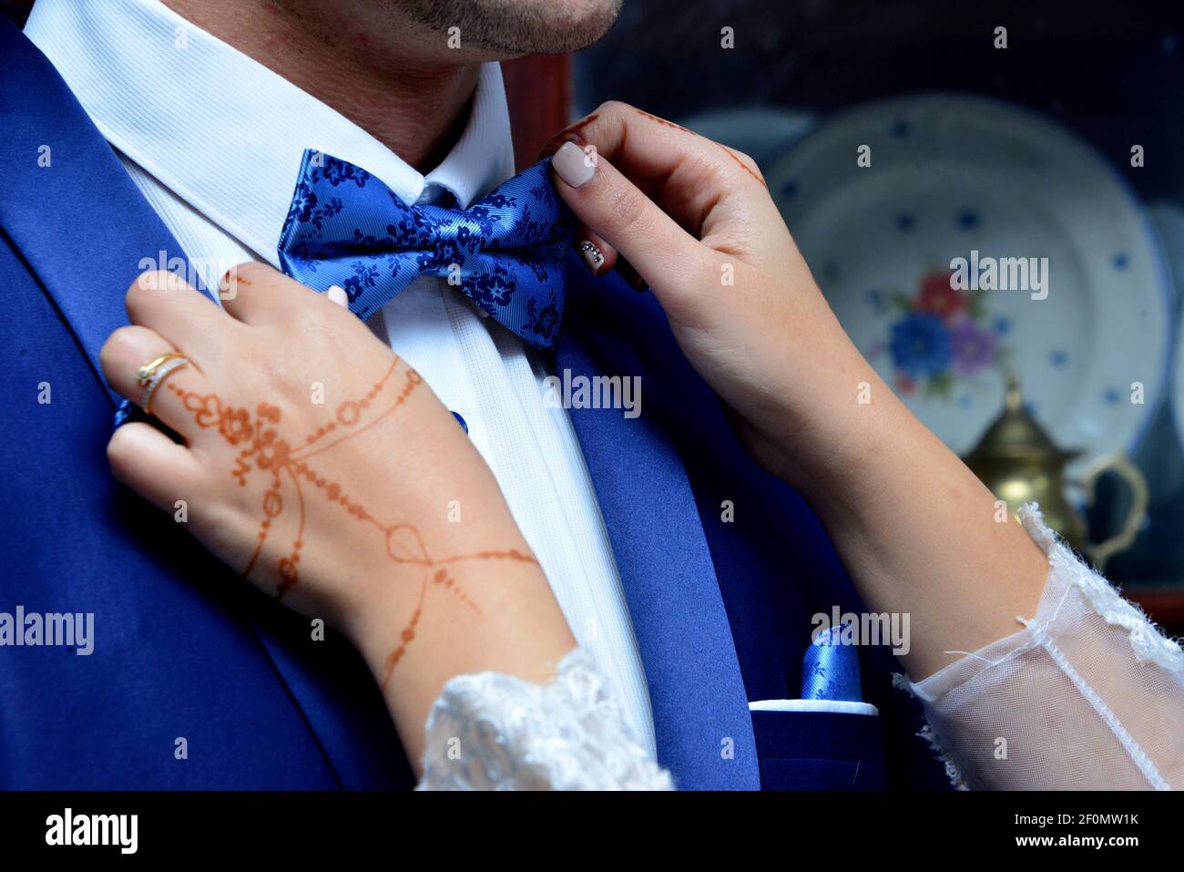 Arab bride ties her husband's necktie. Henna tattoo on the bride's hand Stock Photo