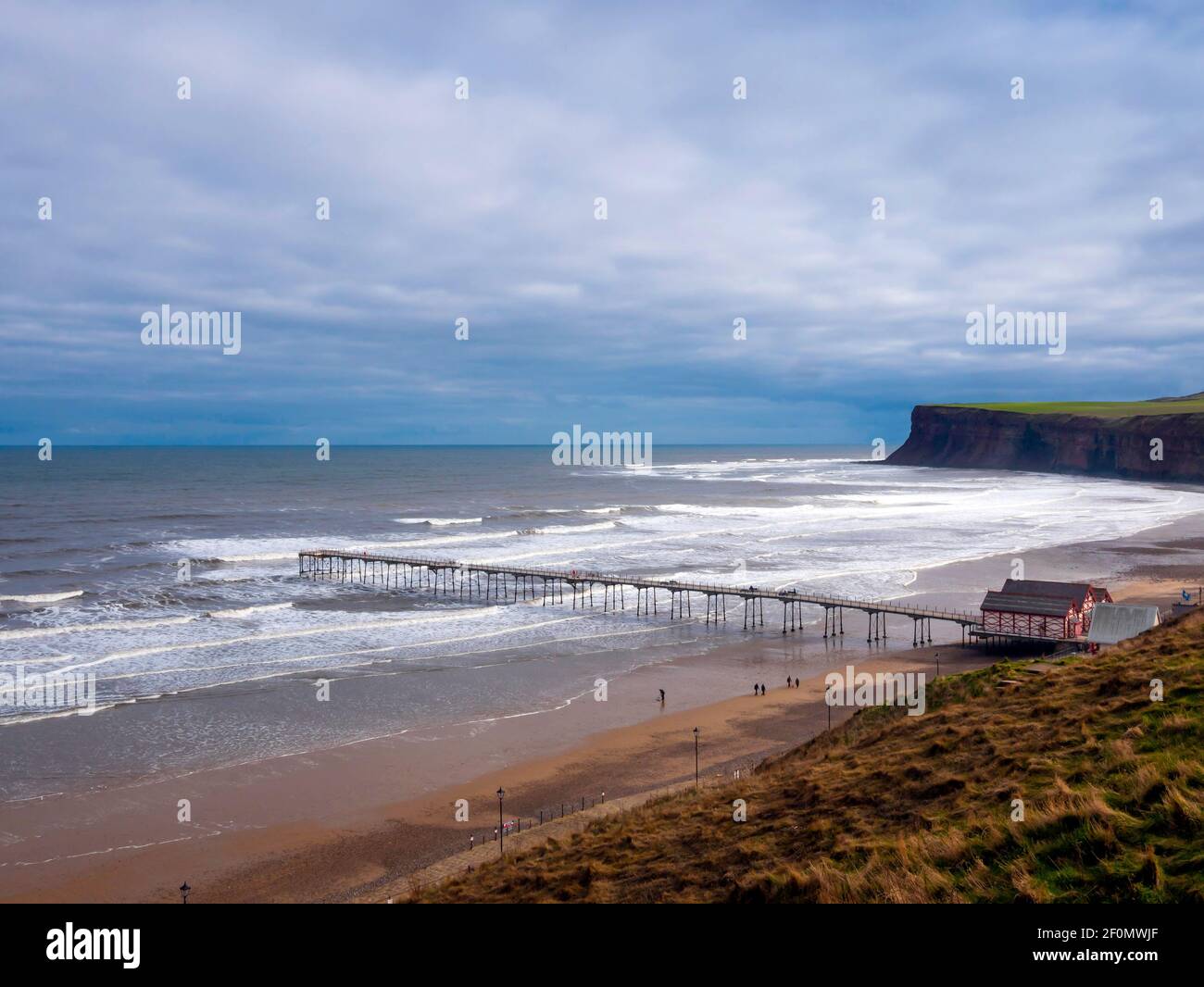 Saltburn pier on a winters day with a grey sky and high waves Stock Photo