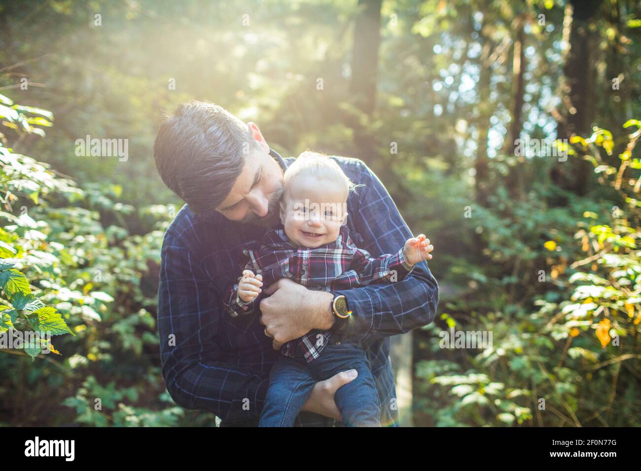 Father holding, loving young son outdoors. Stock Photo