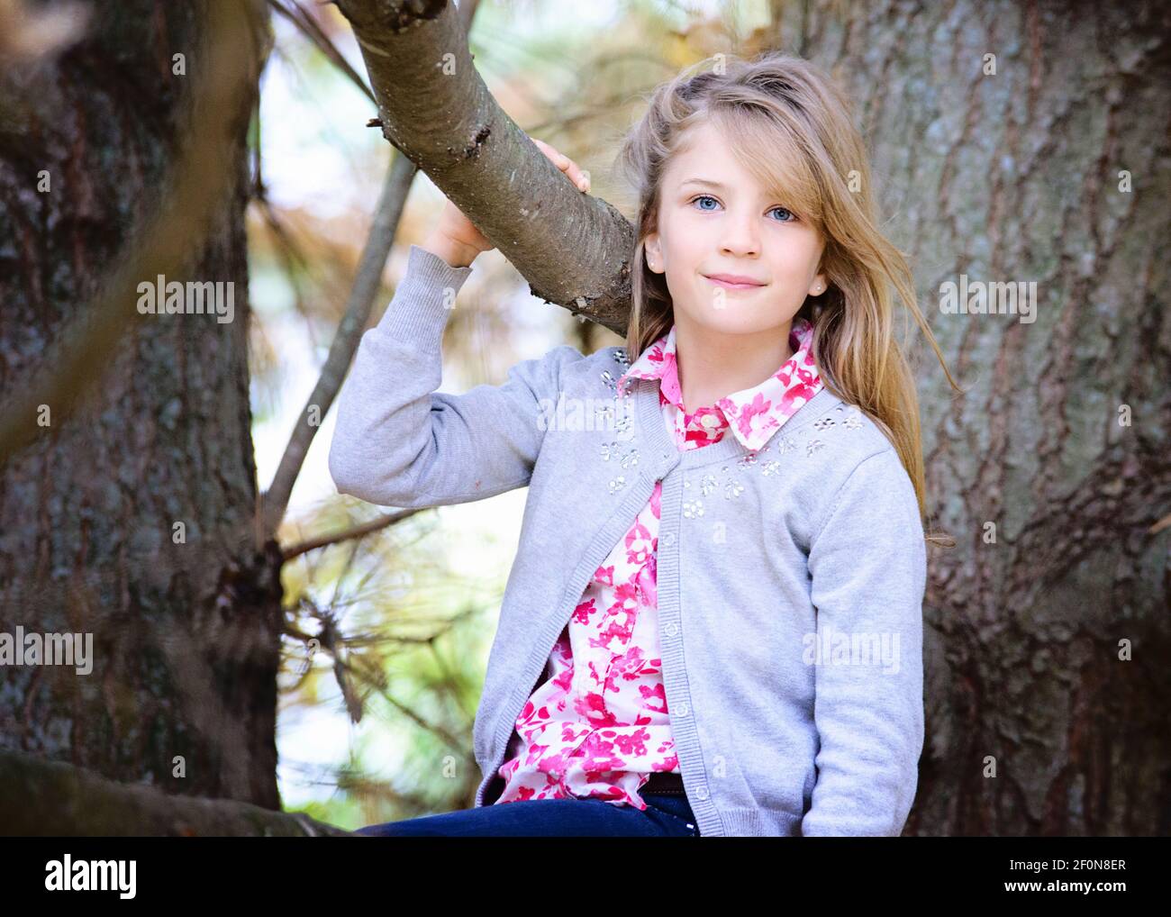 Young Blond Girl Outside Sitting In A Tree Stock Photo Alamy