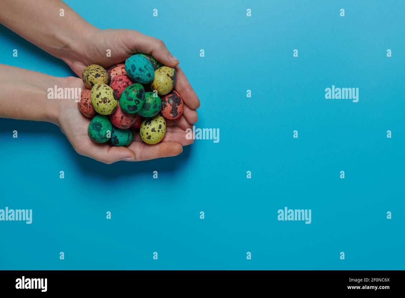 many colored eggs in the palms for easter Stock Photo