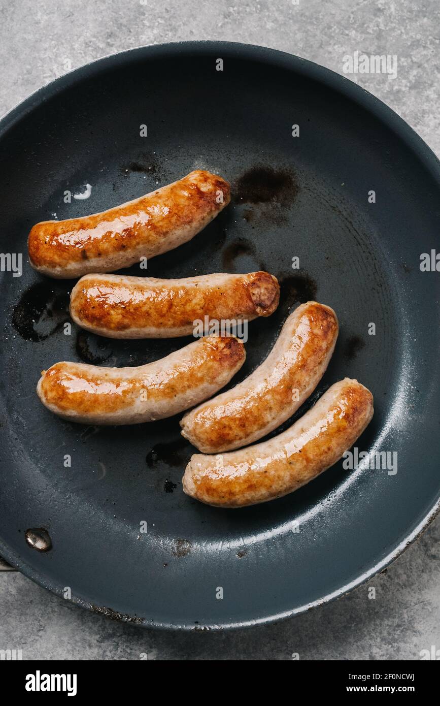 Overhead view of sausage links in a frying pan Stock Photo