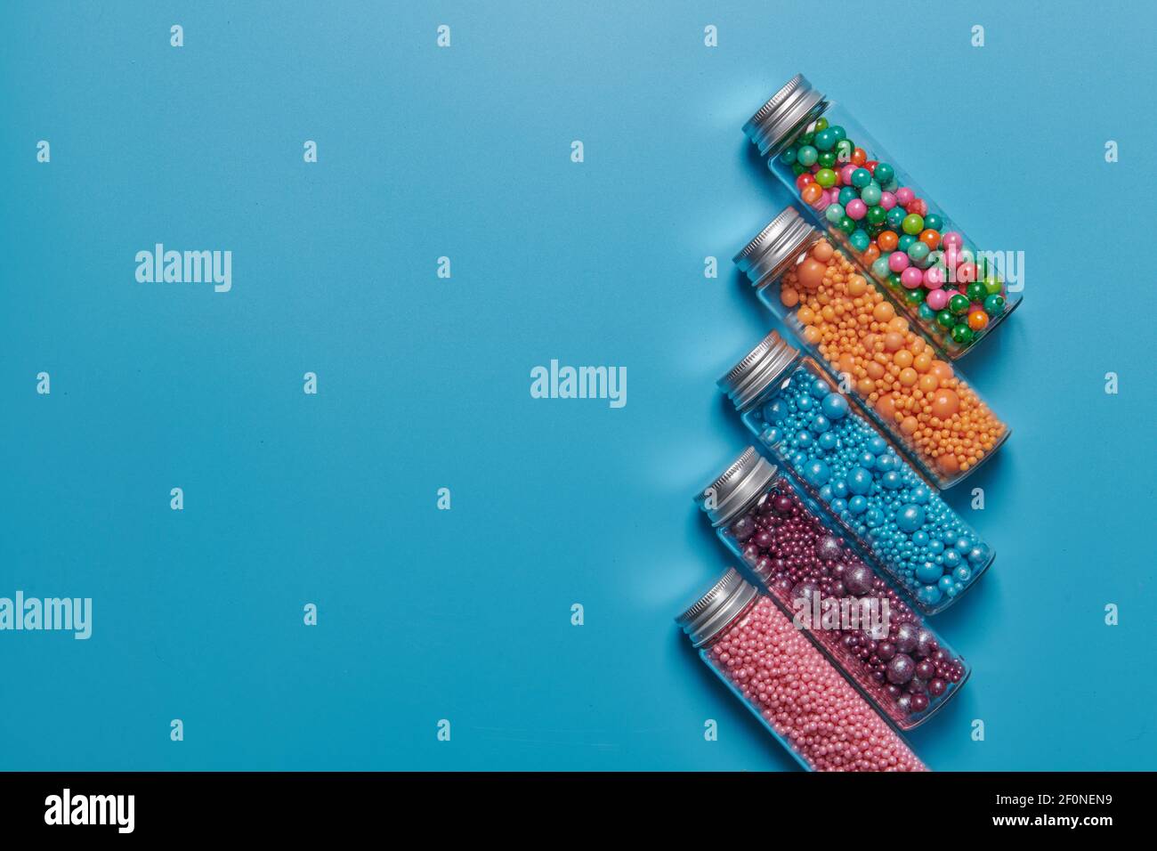 colored candies in jars on a blue background Stock Photo