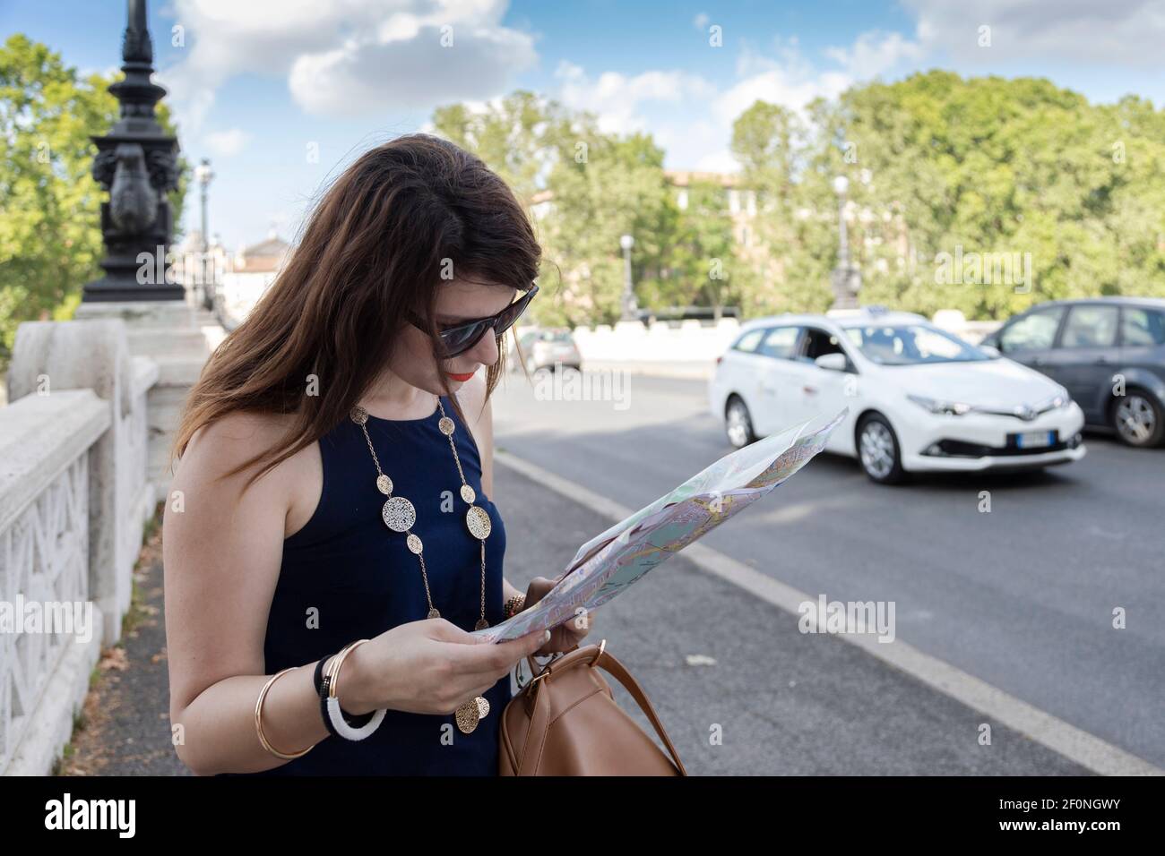 Young woman looking at a map on the side of the street in Florence, Italy. Stock Photo