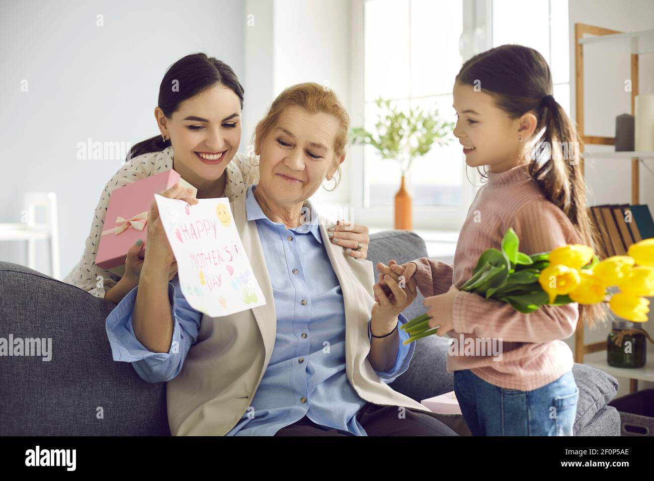 Grandmother holding a beautiful card made for her by her adult daughter and little granddaughter. Stock Photo