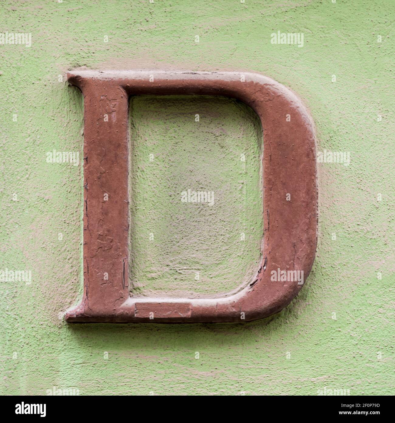 Brown letter D with serifs on green house wall Stock Photo Alamy