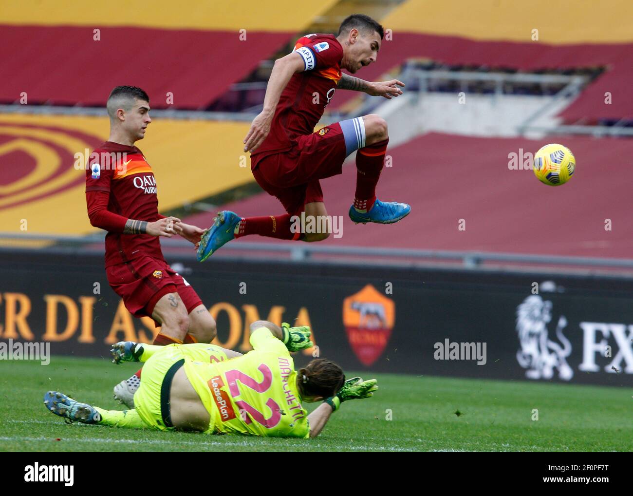 Rome, Italy. 07th Mar, 2021. RomaÕs Lorenzo Pellegrini, right, jumps over Genoa's goalkeeper Federico Marchetti, bottom, past RomaÕs Gianluca Mancini, during the Italian Serie A Football match between Roma and Genoa at the Olympic stadium. Credit: Riccardo De Luca - Update Images/Alamy Live News Stock Photo