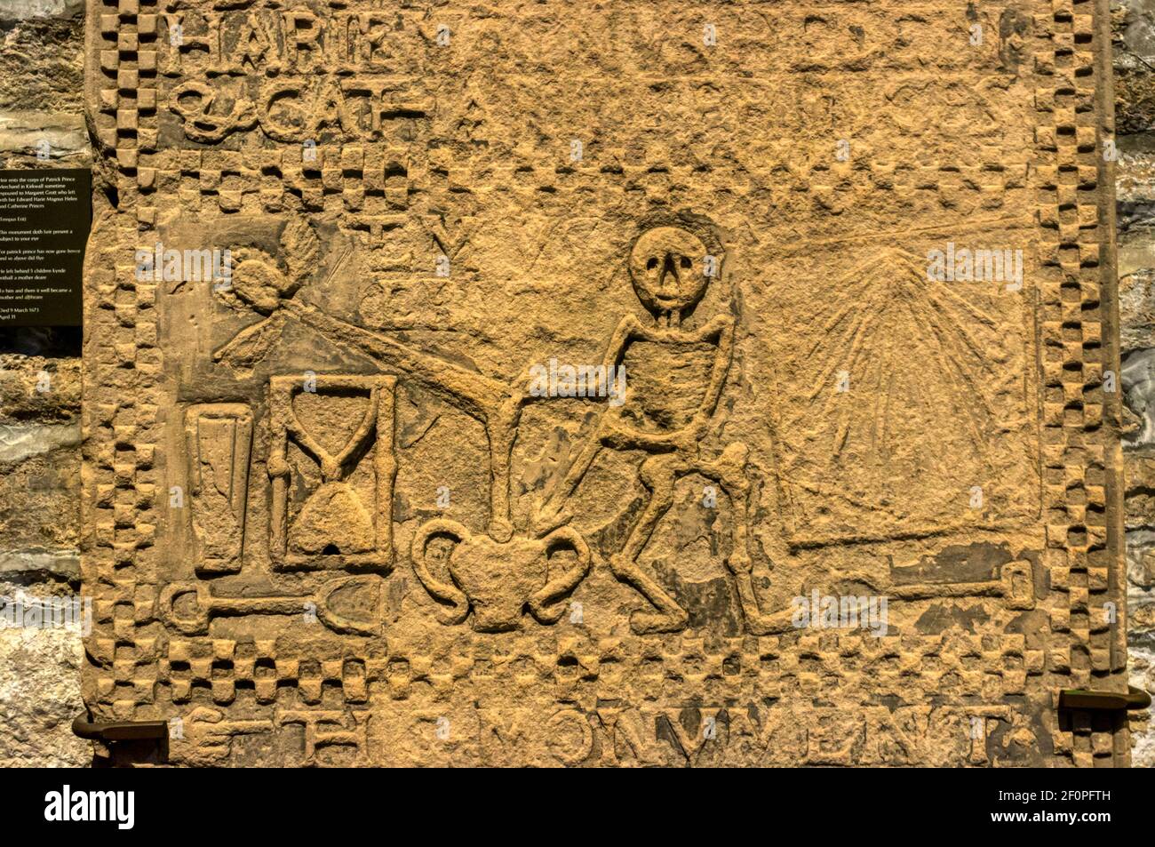 Memento mori carving on gravestone of Patrick Prince in Kirkwall cathedral, Orkney. Shows dancing Death striking urn with a dart, + spade & hourglass. Stock Photo