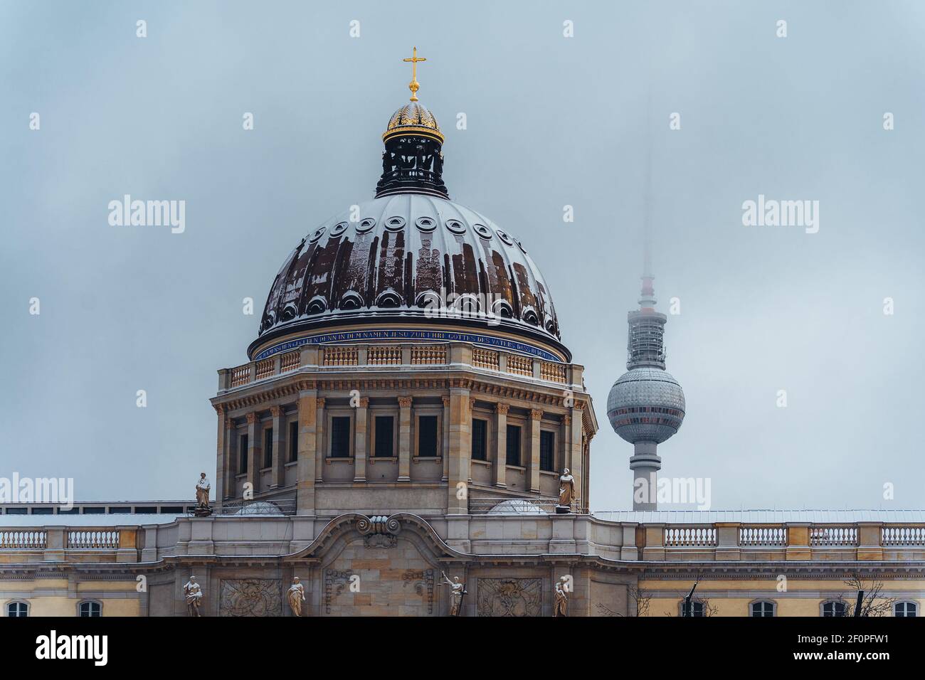 Snow covered dome of the the Royal Castle or city palace and Humboldt Forum with tv tower in background in Berlin Mitte on a cold winter day after Stock Photo