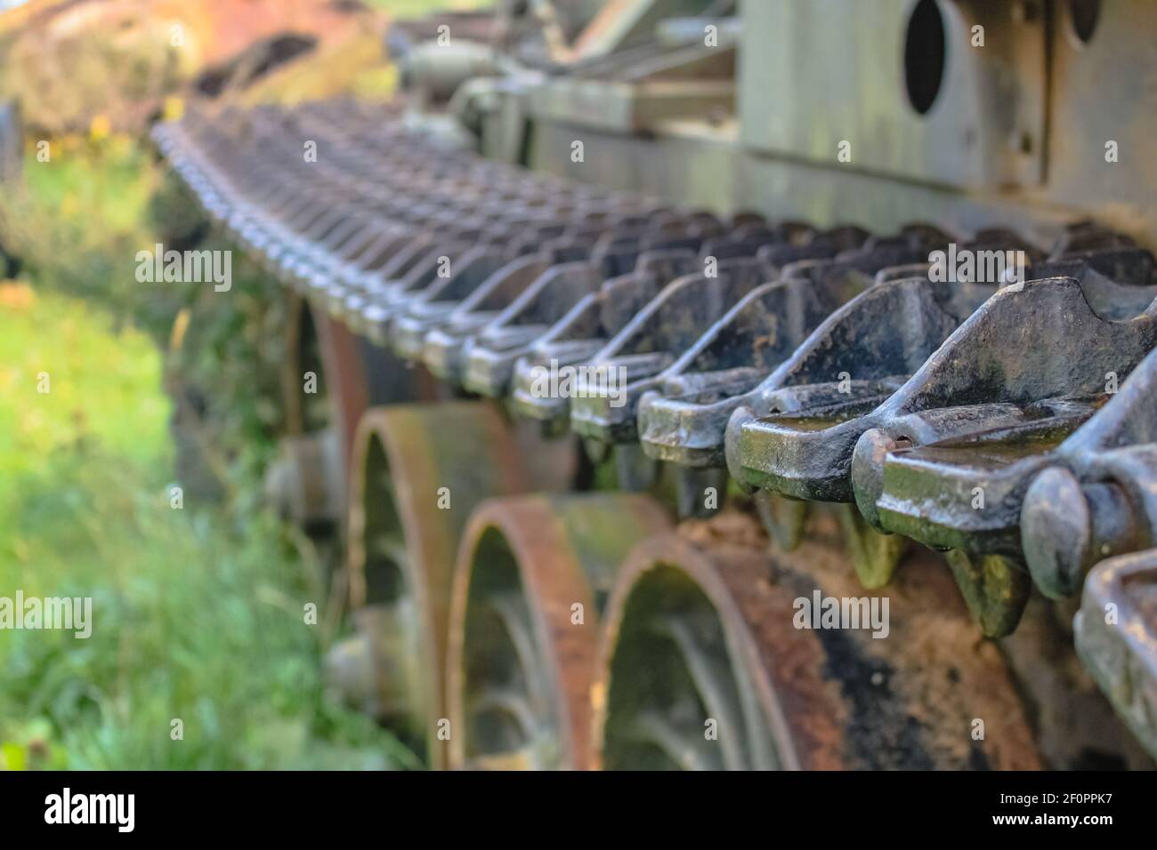 The caterpillar of an old Soviet tank on the background of rusty wheels. Selective Focus Stock Photo
