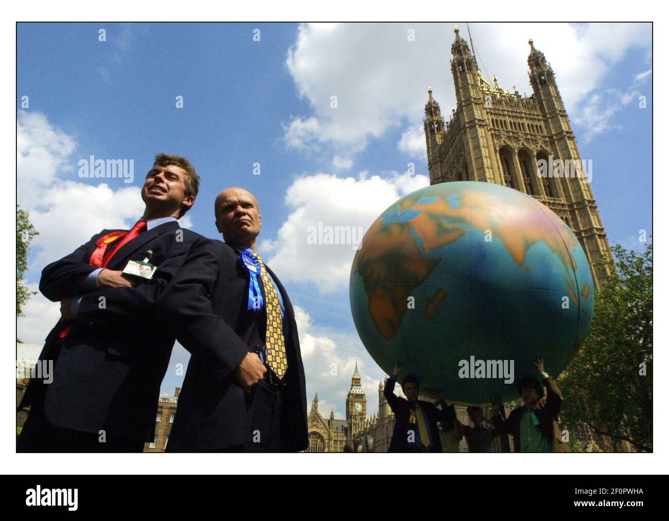 The General Election June 2001  Friends of the Earth  Tony Blair and William Hague lookalikes join Lib Dem enviroment spokesman Tom Brake and Green Party Principal spokesperson Mike Woodin in blowing up a giant globe outside Parliament Stock Photo