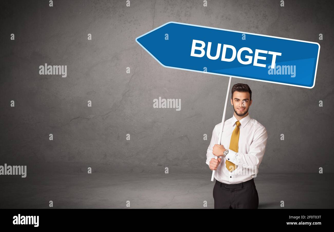 Young business person in casual holding road sign with BUDGET inscription, new business direction concept Stock Photo