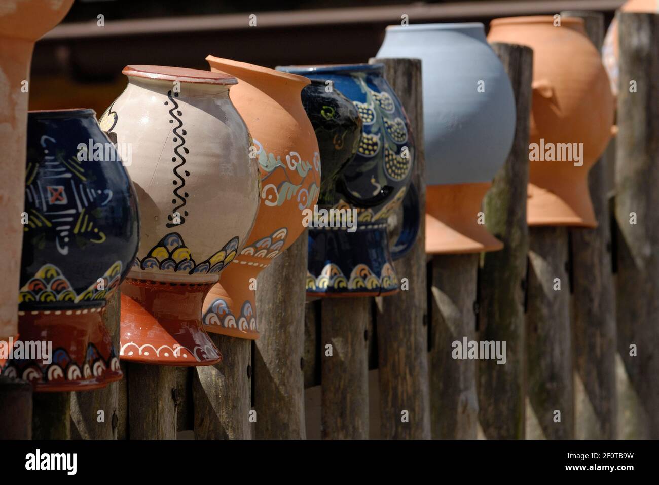 Wooden fence with painted clay jugs Stock Photo