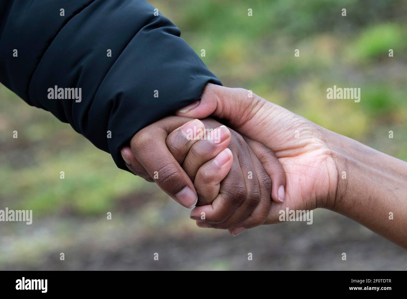 A Somali woman who fled to Germany holds the hand of her eight-year-old son, whom she was able to bring back to Germany after months of separation Stock Photo
