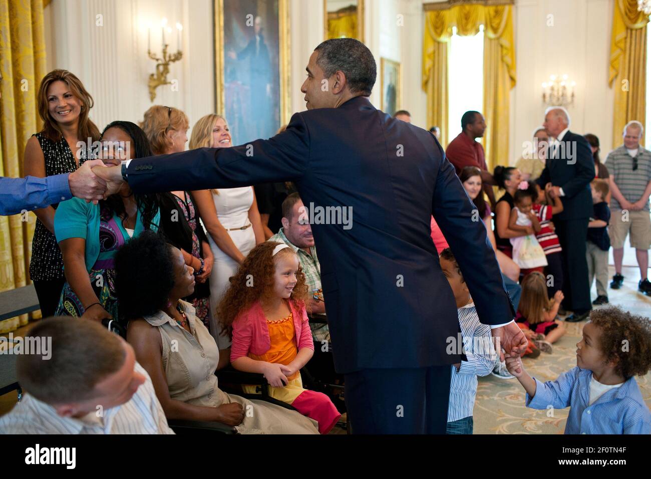 Reportage:  July 5 2011; President Barack Obama shakes hands with a wounded warrior and the child of a wounded warrior in the East Room. Stock Photo