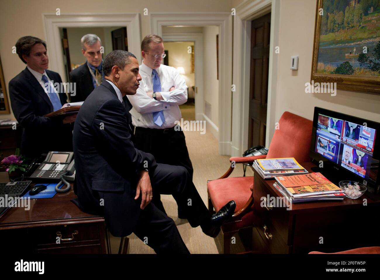 President Barack Obama watches a televised speech by President Hosni Mubarak of Egypt in the Outer Oval Office Jan. 28 2011. With the President from left are: Tony Blinken National Security Advisor to the Vice President; Deputy National Security Advisor Denis McDonough; and Press Secretary Robert Gibbs. Stock Photo