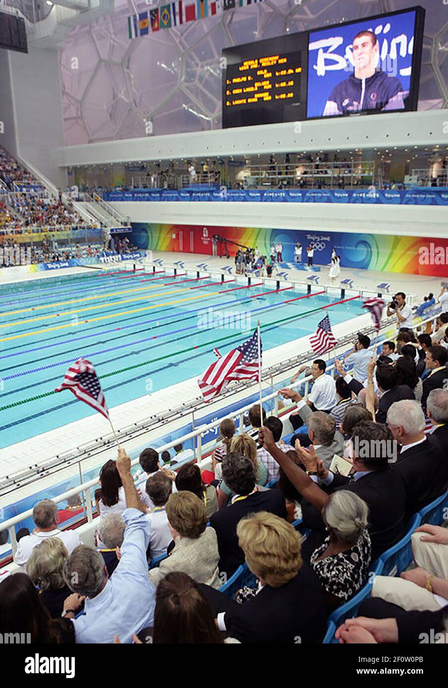 President George W. Bush waves an American flag as U.S. swimmer Michael Phelps is presented his gold medal after winning the 400-meter Individual Medley Sunday Aug. 10 2008 at the 2008 Summer Olympics in Beijing. Stock Photo