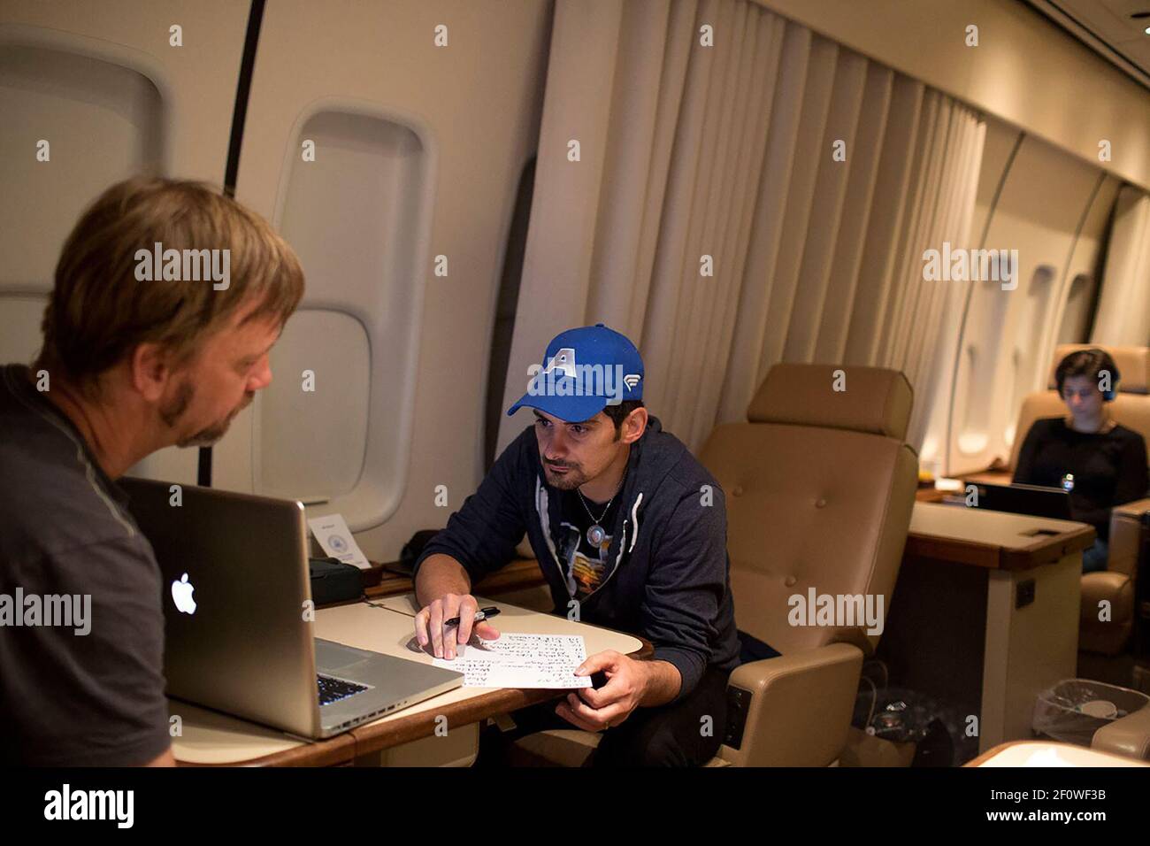 Country singer Brad Paisley works on his setlist with Kendal Marcy, left, aboard Air Force One en route to Bagram Airfield, Afghanistan with President Barack Obama to visit U.S. troops, Sunday, May 25, 2014 Stock Photo