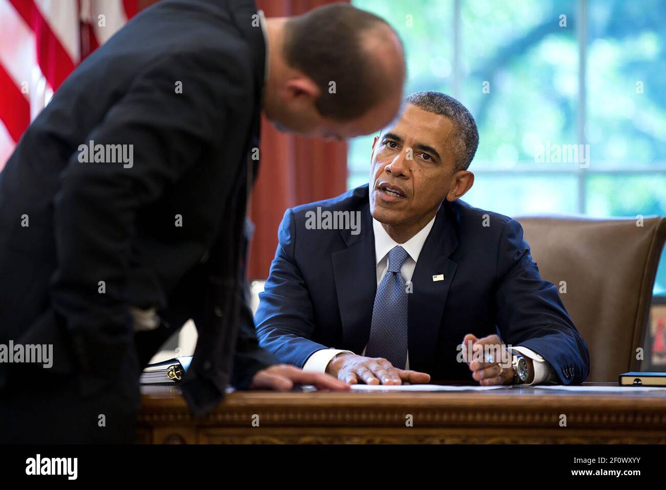 President Barack Obama confers with Ben Rhodes, Deputy National Security Advisor for Strategic Communications, in the Oval Office before delivering a statement on the situation in Ukraine, July 21, 2014 Stock Photo