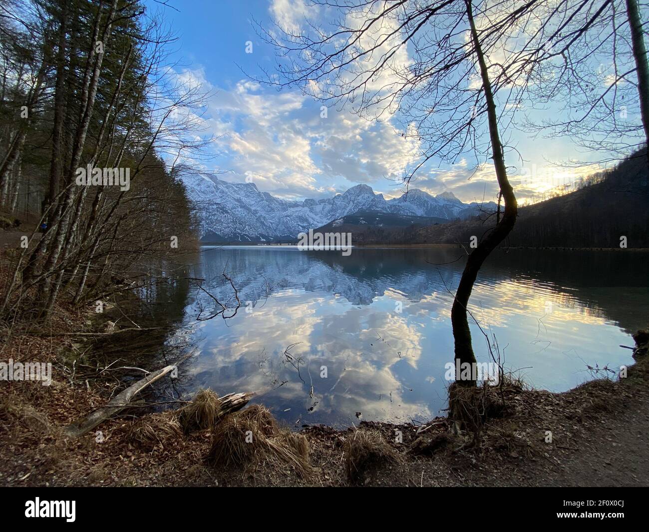 Reflections of a sunset over alpine mountain lake Almsee in Austria Stock Photo