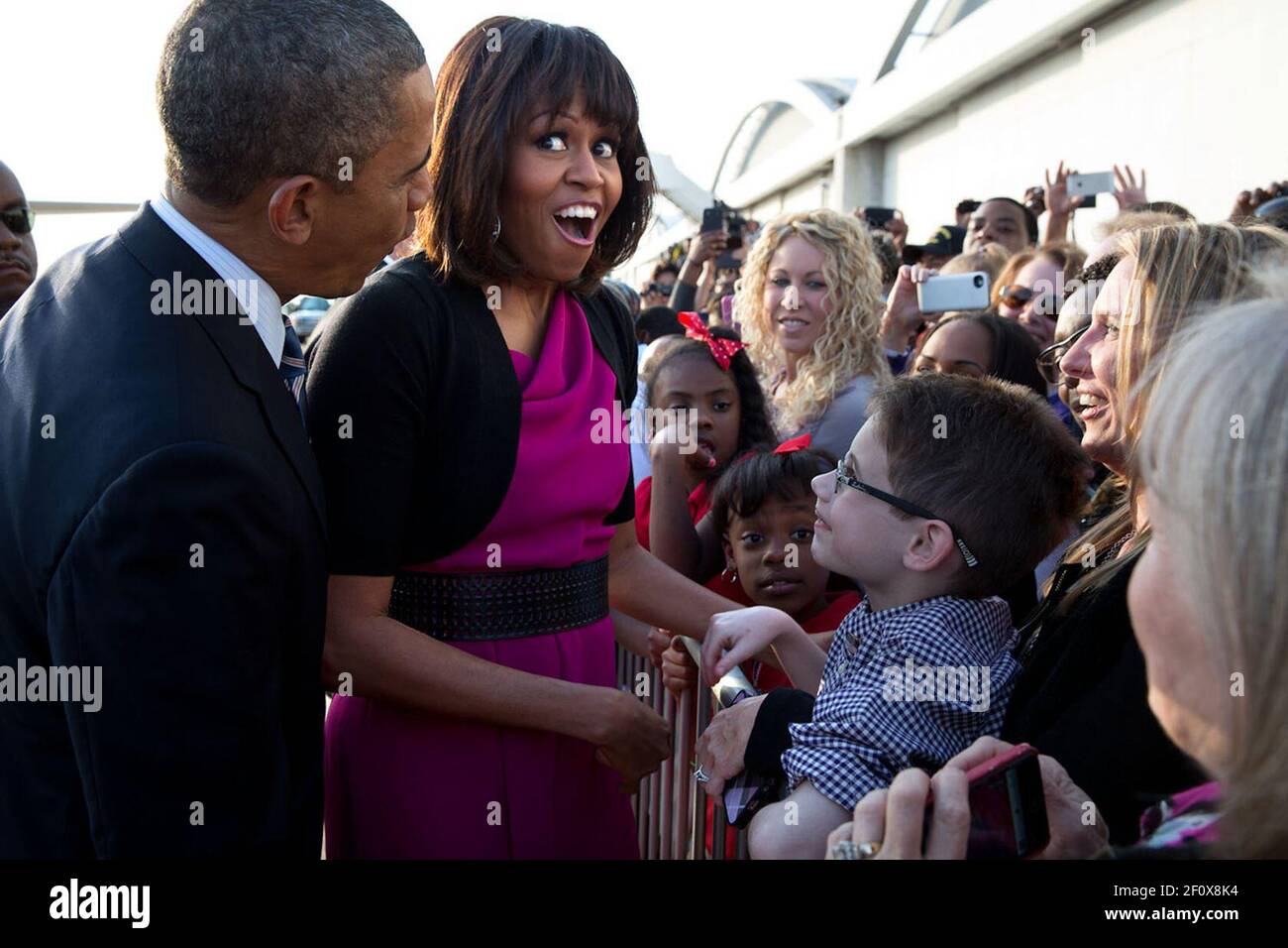 First Lady Michelle Obama reacts while talking with a youngster along a rope line with President Obama at Love Field Airport in Dallas, Texas ca. April 24, 2013 Stock Photo