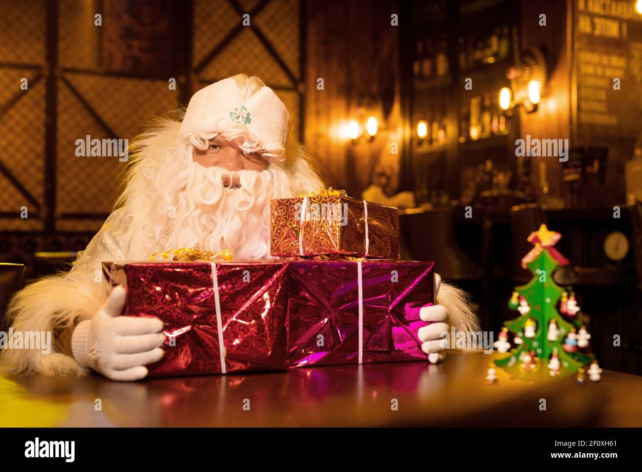 Santa Claus with pile of gifts in bar Stock Photo