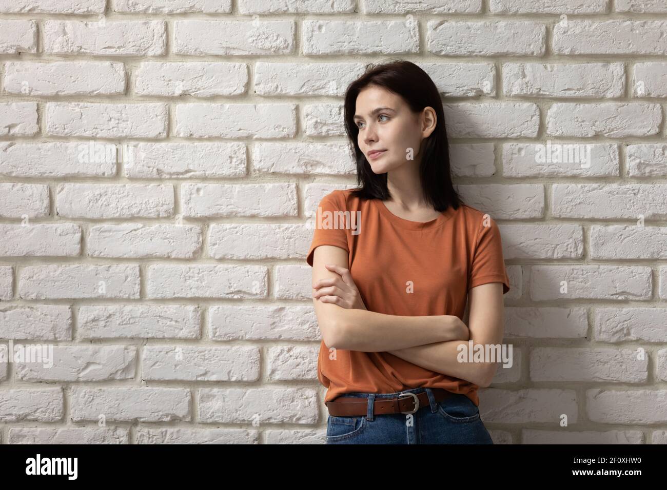 Ambitious young lady stand by wall cross arms look away Stock Photo