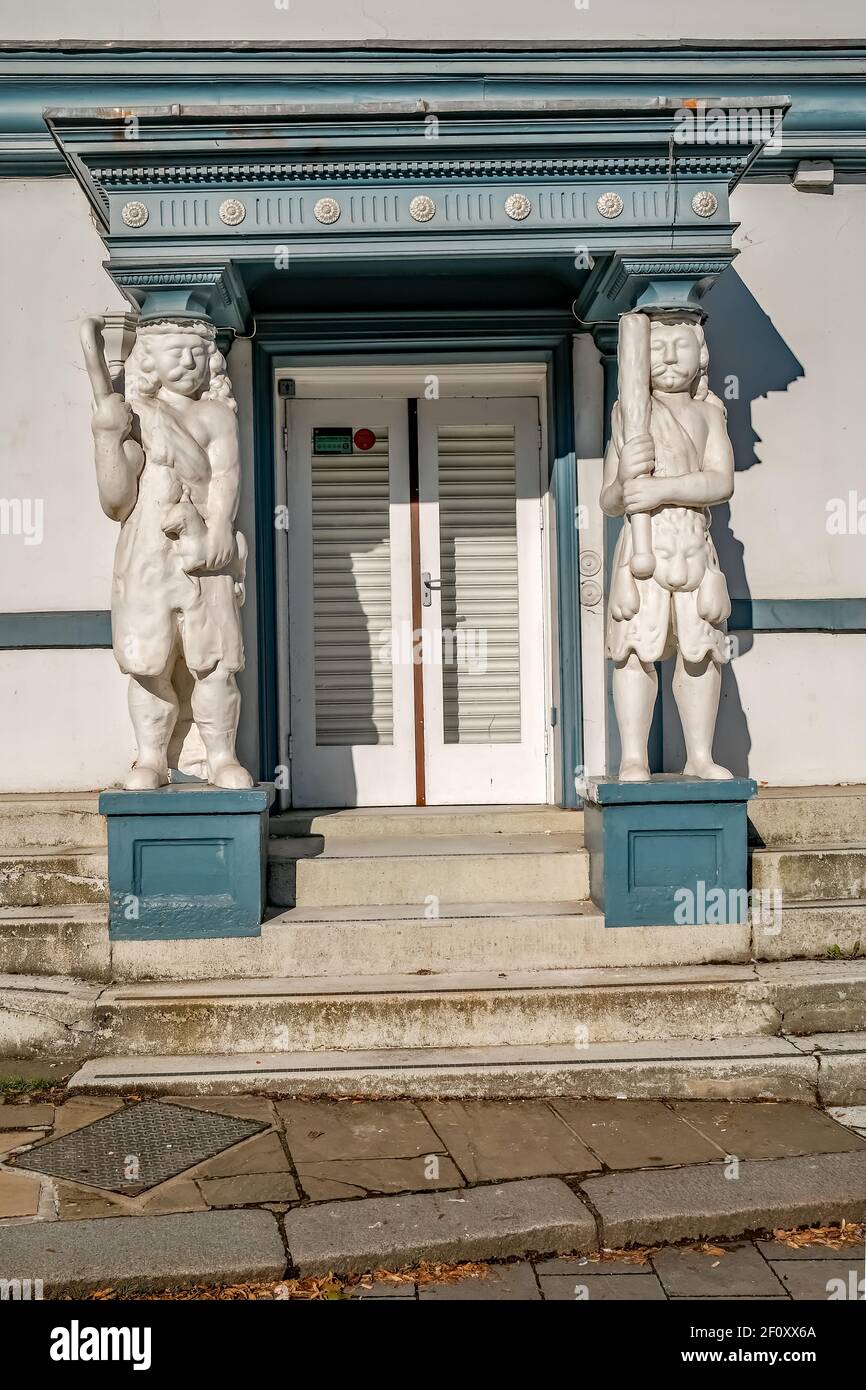 Historical twin statues in the doorway of a Tudor style building in the