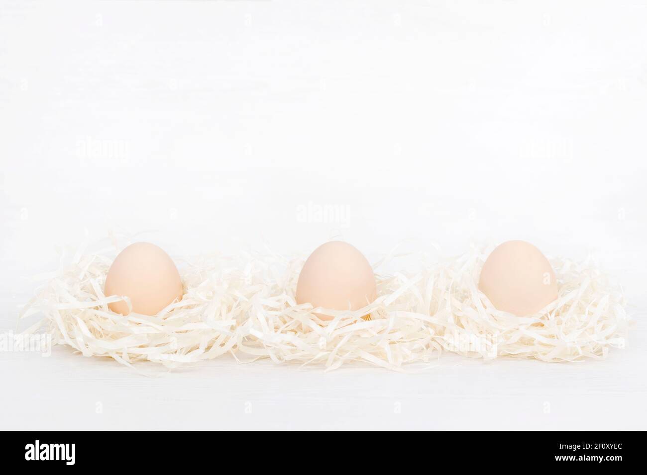 Raw organic three brown eggs in nest made of staw shreded paper Stock ...