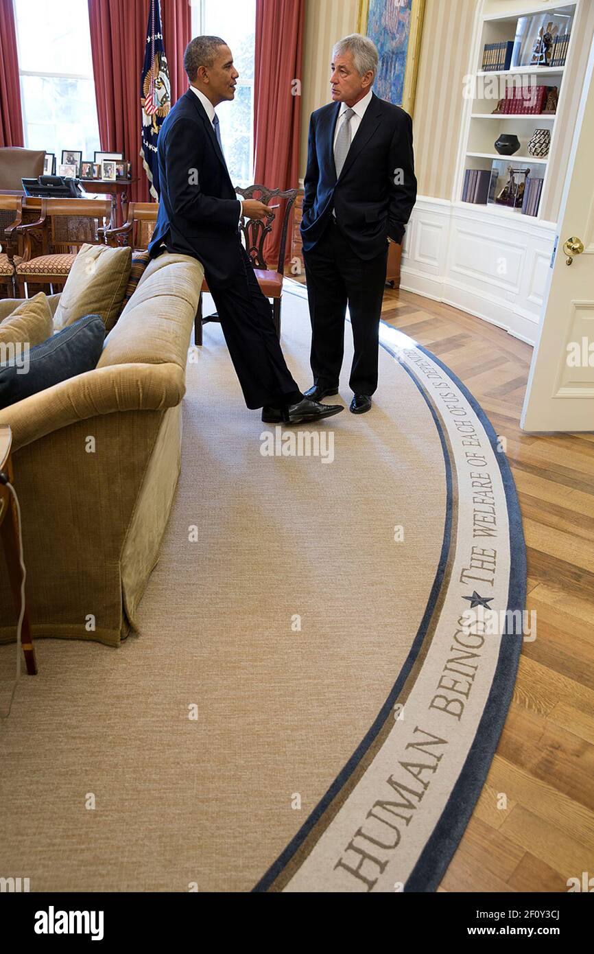 President Barack Obama talks with Defense Secretary Chuck Hagel in the Oval Office during a break in the bilateral meetings with President François Hollande of France  Feb. 11 2014. Stock Photo