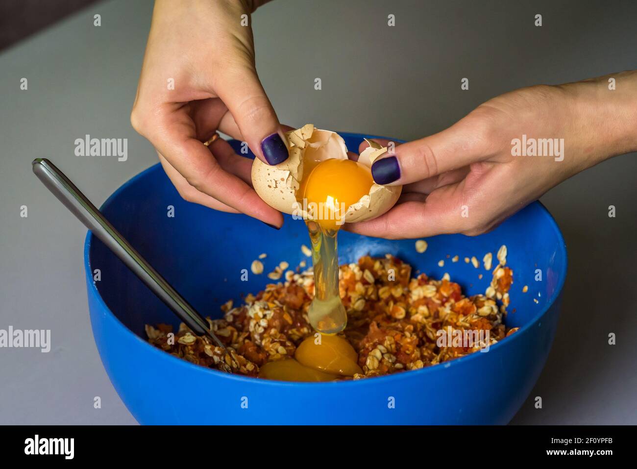 Hand pours out raw egg of the shell Stock Photo