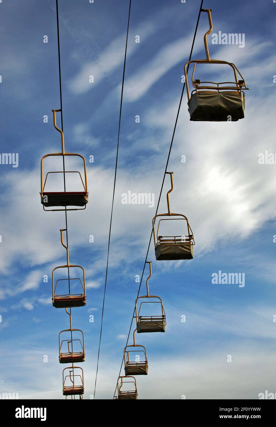 Empty chairlifts traveling back and forth. Stock Photo