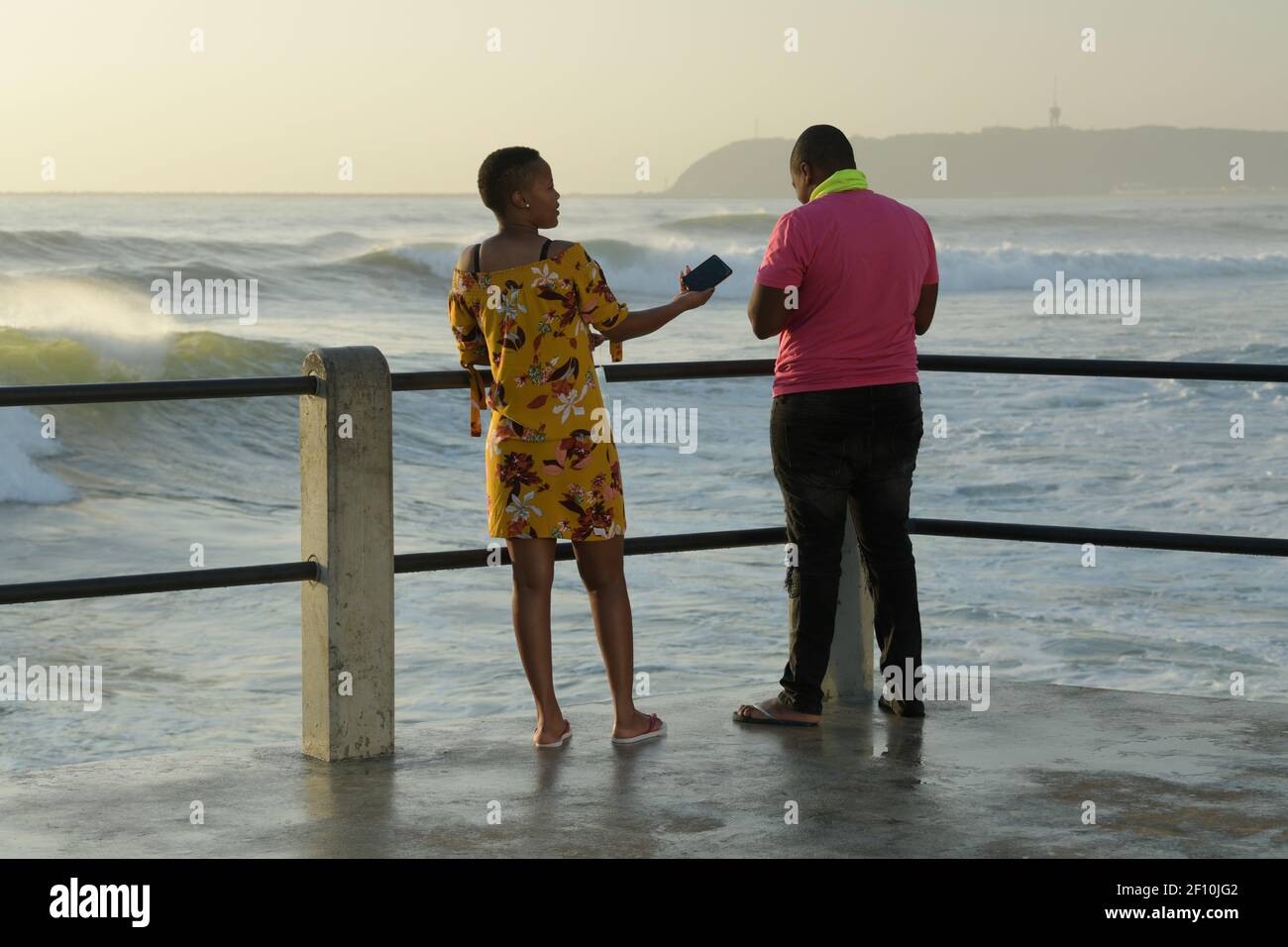 Adult couple, man, woman, standing on pier, looking at sea, ethnic, local tourist, Durban, South Africa, seaside holiday, beach vacation, partners Stock Photo