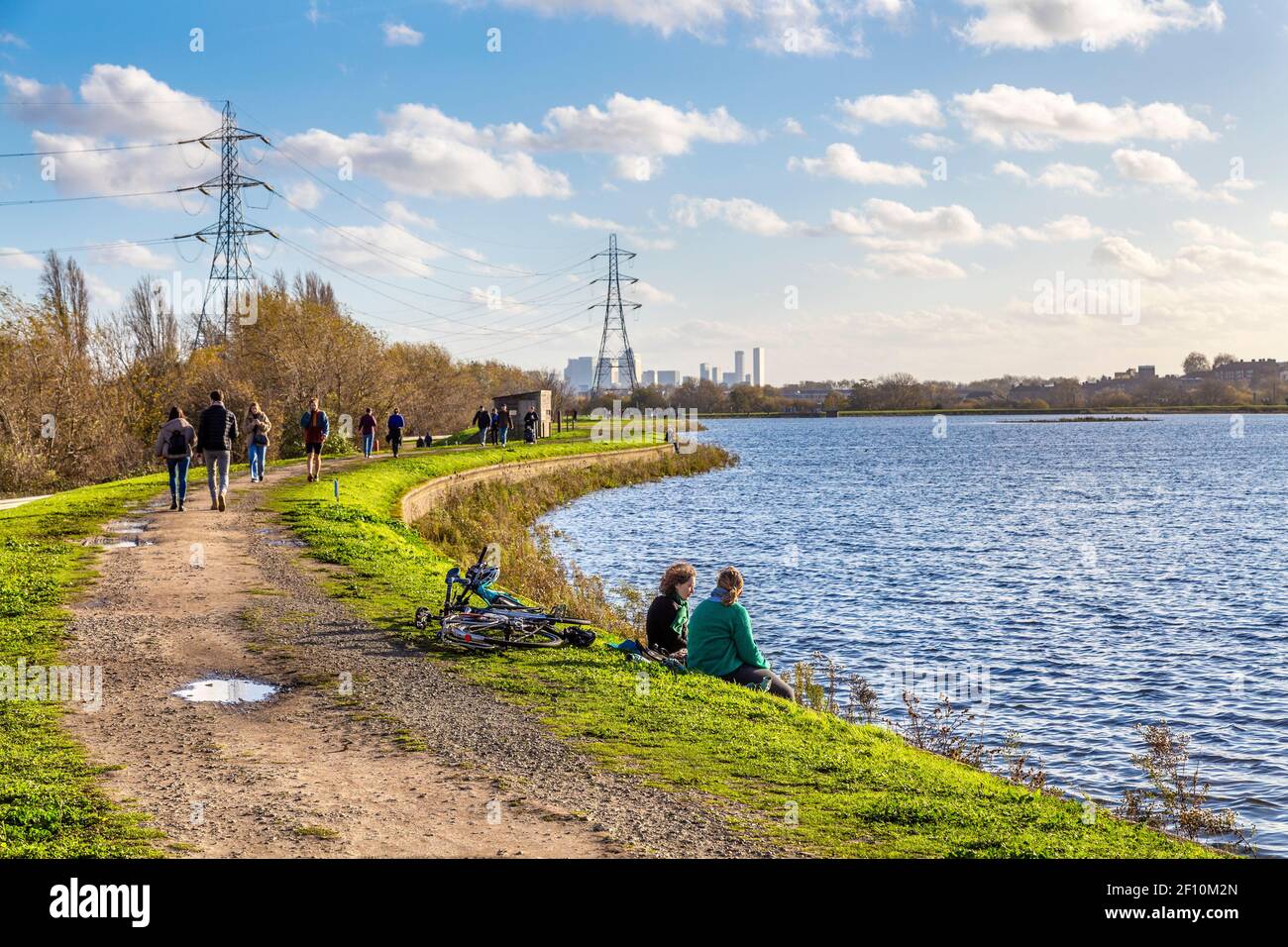 People walking and relaxing by the East Warwick Reservoir in Walthamstow Wetlands, Lea Valley Country Park, London, UK Stock Photo