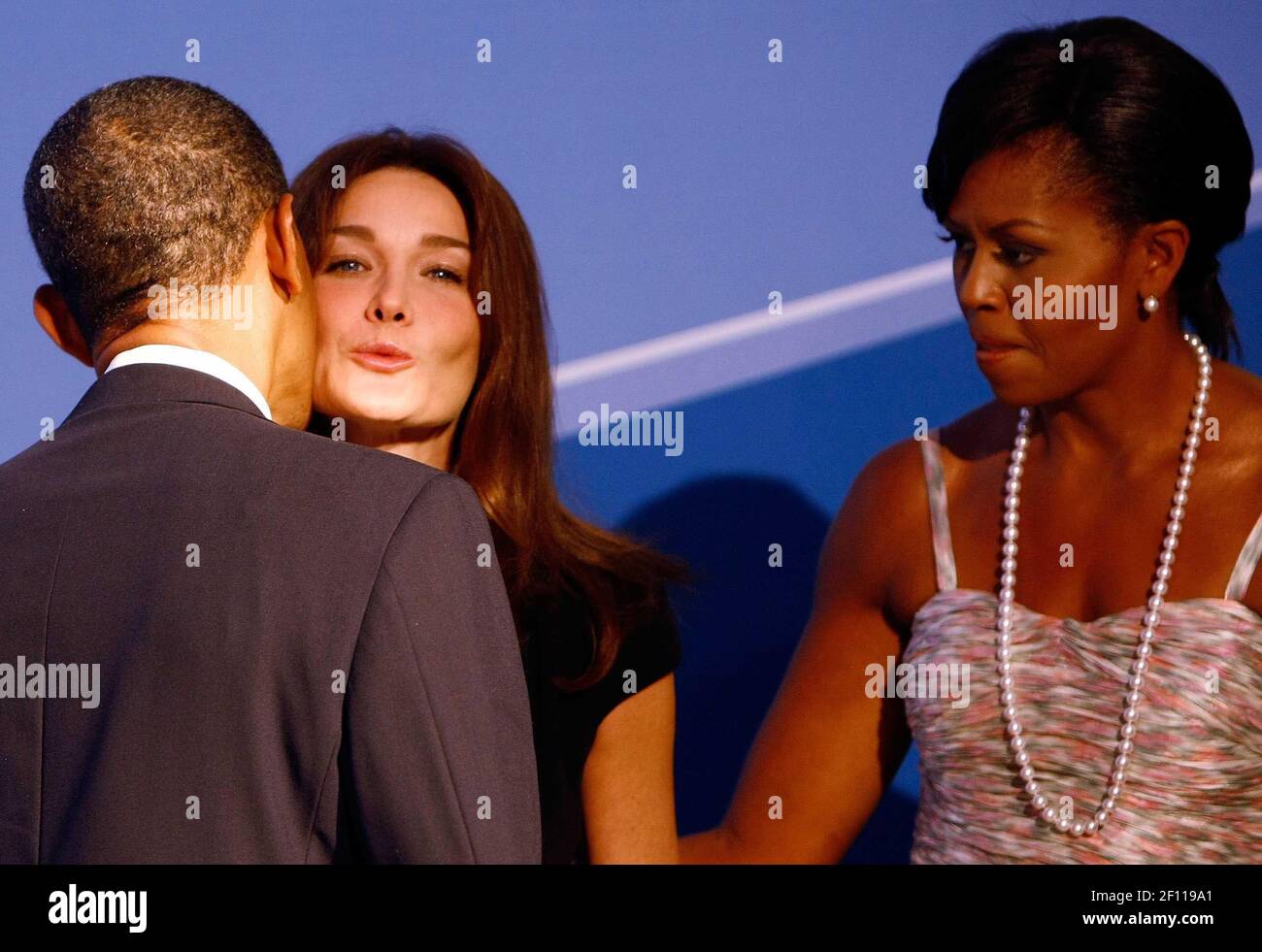 24 September 2009 - Pittsburgh, Pennsylvania - U.S. President Barack Obama (L) kisses French President Nicolas Sarkozy's wife Carla Bruni Sarkozy (C) while welcoming her to the opening dinner for G-20 leaders with U.S. first lady Michelle Obama at the Phipps Conservatory on September 24, 2009 in Pittsburgh, Pennsylvania. Heads of state from the world's leading economic powers arrived today for the two-day G-20 summit held at the David L. Lawrence Convention Center aimed at promoting economic growth. Photo Credit: Win McNamee/Pool/Sipa Press/0909251406 Stock Photo
