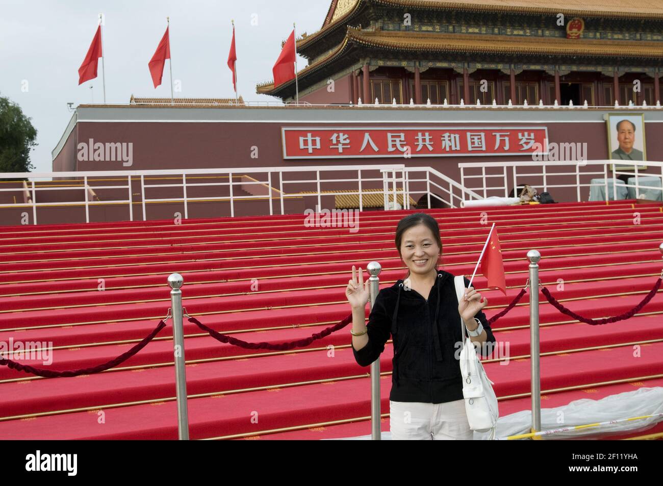 A young woman is getting photographed in front of the forbidden city and the portrait of Mao, on the wall:'Long life to the People's Republic of China, for ever'. (Photo by Raphael Fournier/Sipa USA) Stock Photo