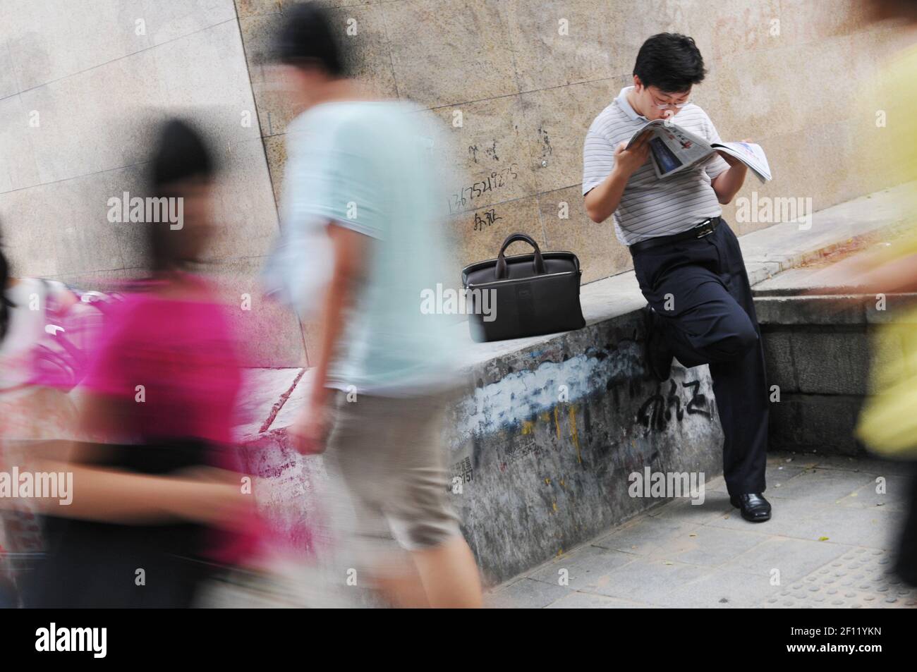 A Chinese worker reading a magazine in Beijing CBD. (Photo by Raphael Fournier/Sipa USA) Stock Photo