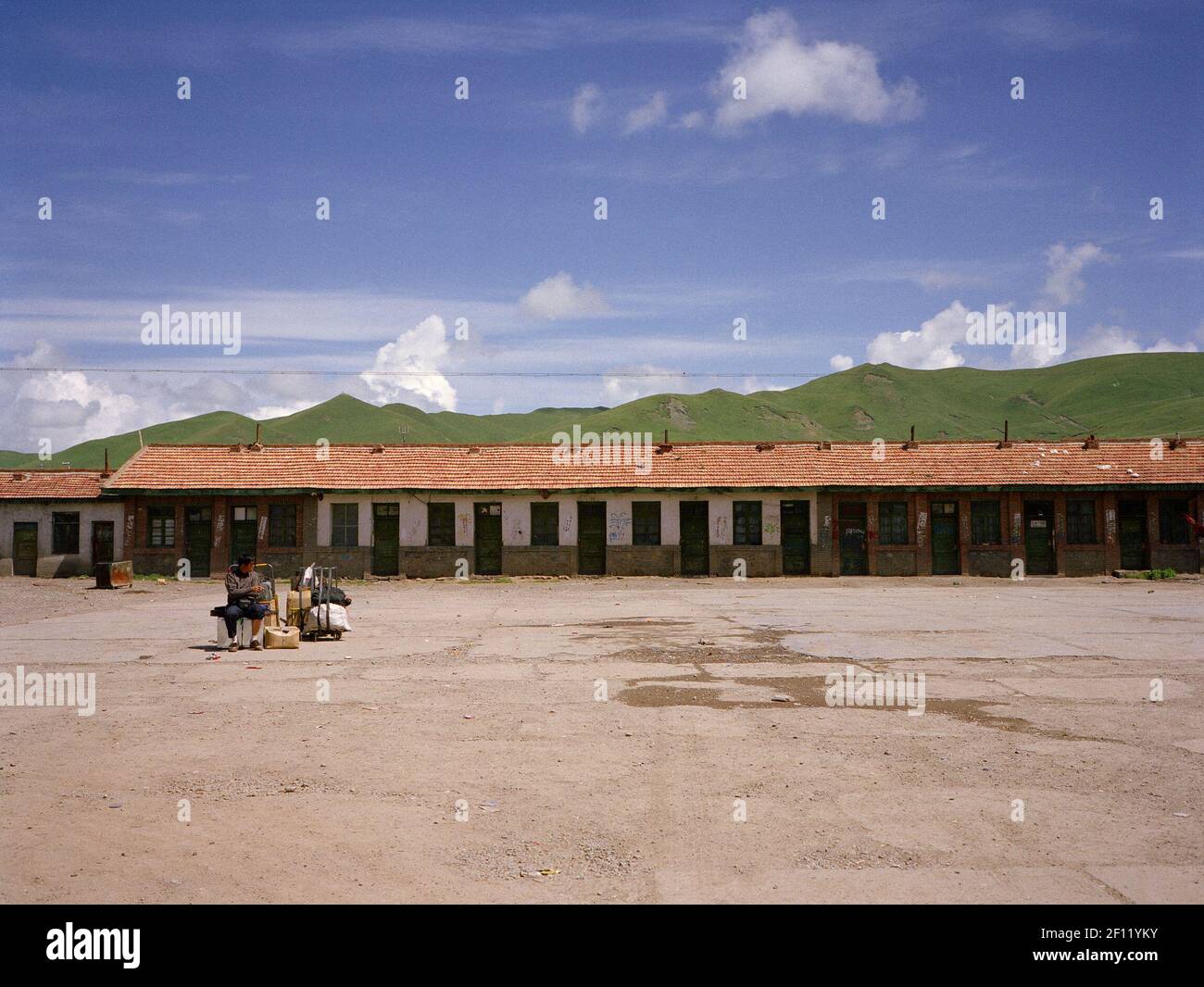 A man waiting in a newly built Tibetan city's bus station. (Photo by Raphael Fournier/Sipa USA) Stock Photo