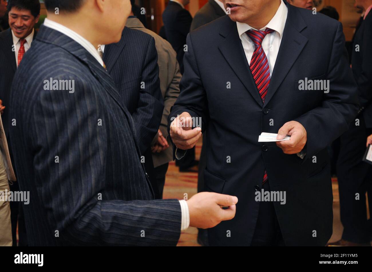 Chinese workers exchanging name cards in one of the Beijing CBD towers. (Photo by Raphael Fournier/Sipa USA) Stock Photo