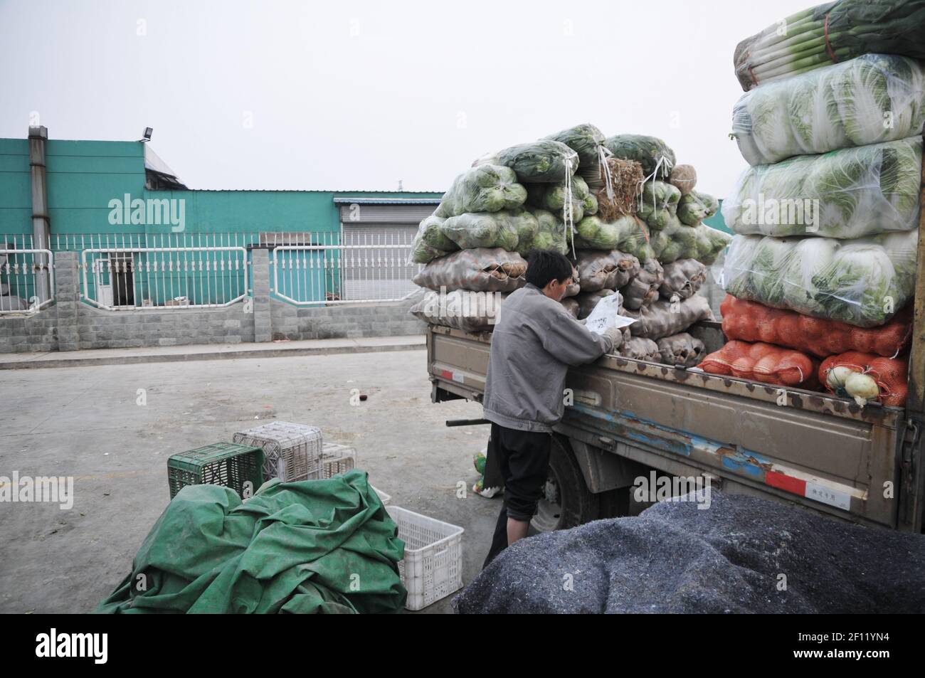 A farmer and his truck full of vegetables just arrived from neighboring Hebei province. (Photo by Raphael Fournier/Sipa USA) Stock Photo