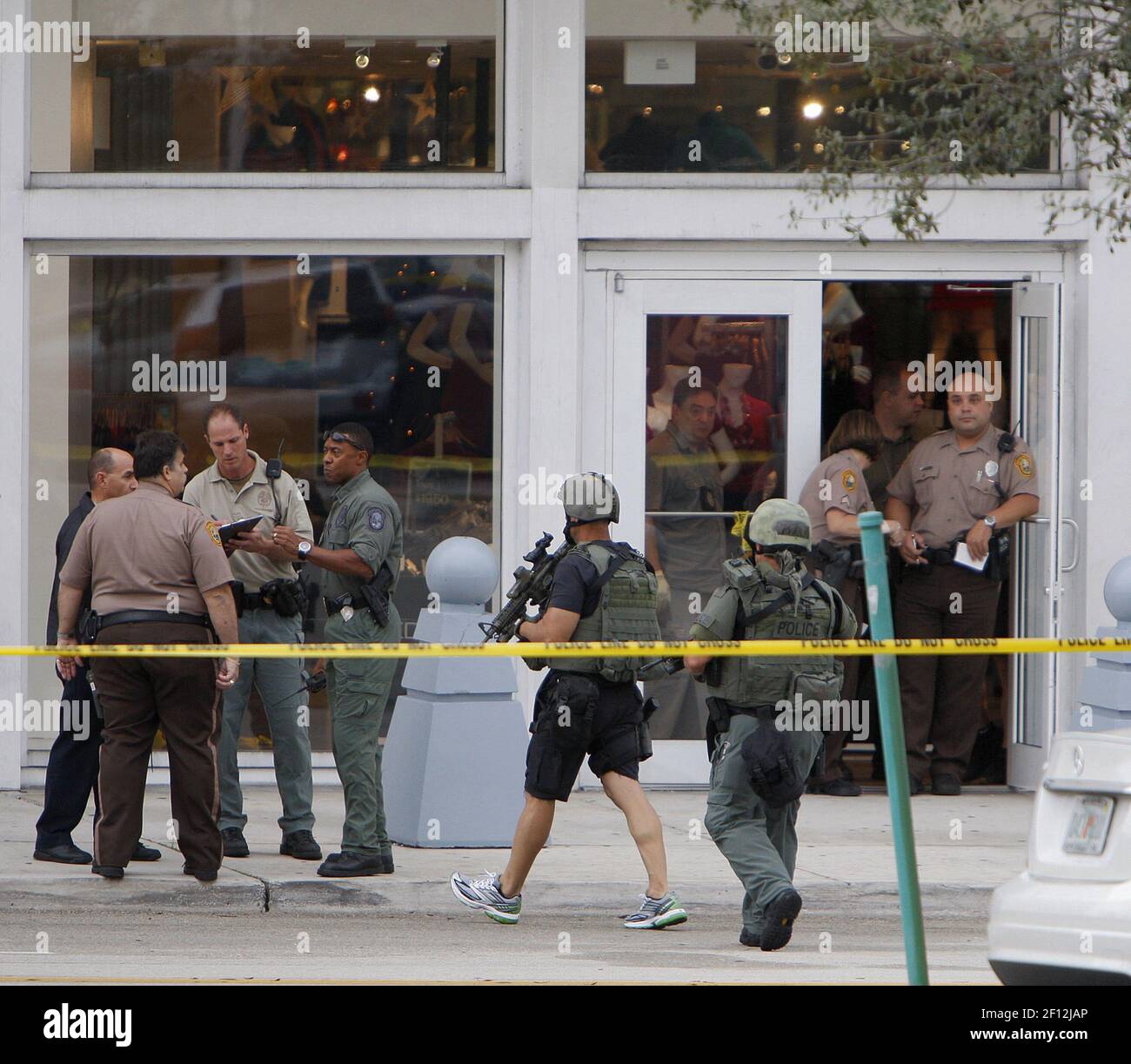 MiamiDade police and SWAT team move near an entrance door to the
