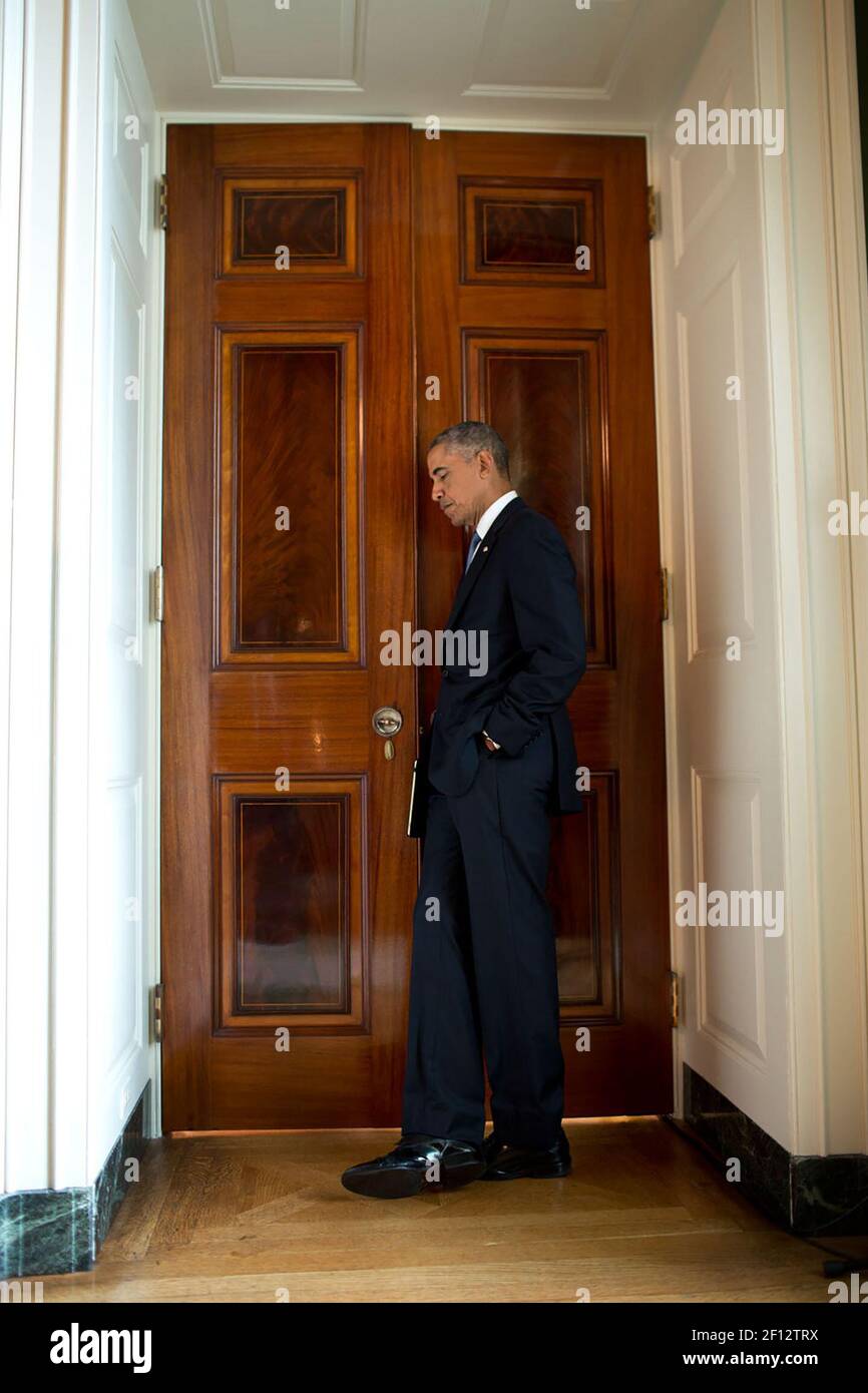 Sept. 19, 2014 - President Barack Obama listens at a cracked door to the East Room in the White House. Stock Photo